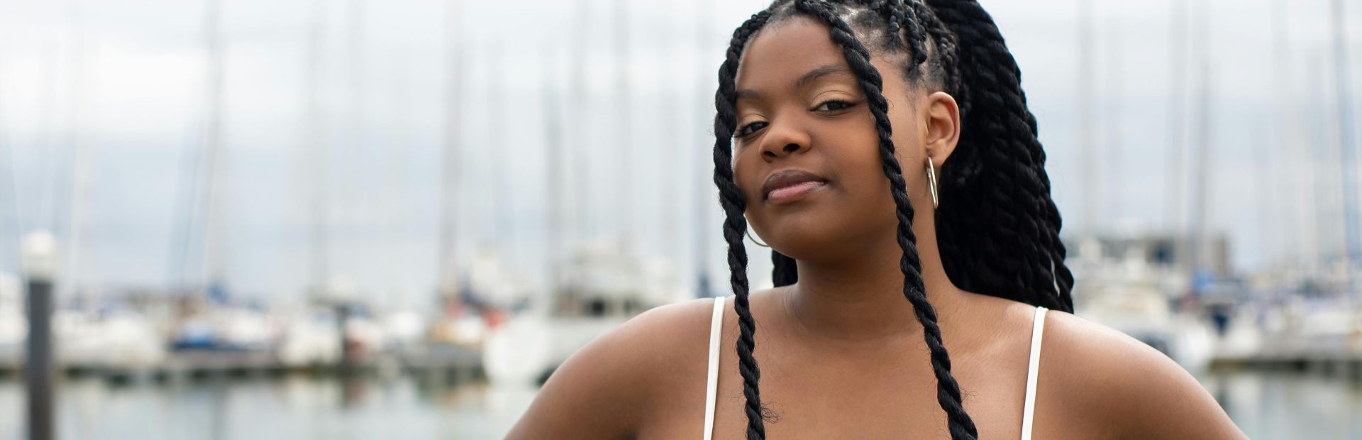 Selective Focus Photo of a Beautiful Woman with Braided Hair Looking at the Camera